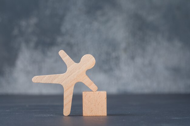 Conceitual de negócios com bloco de madeira com figura humana de madeira.