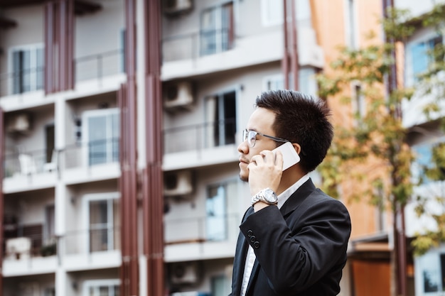 Concept business - homem de negócios conversando seriamente com seu projeto em seu celular