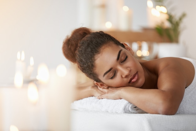 Concurso mulher africana descansando relaxante com os olhos fechados no salão spa.