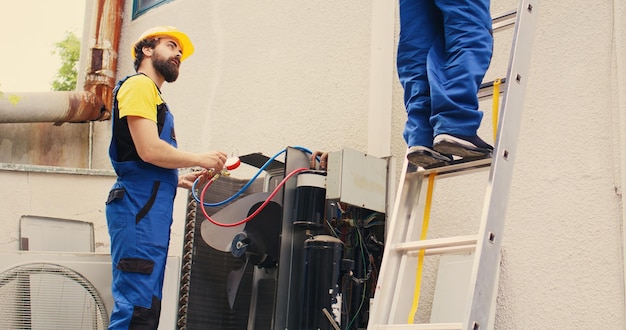 Foto grátis condensador de manutenção especializado e colega de trabalho