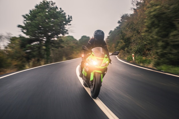 Foto grátis conduzindo a motocicleta de cor verde neon na estrada, vista frontal.