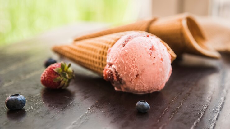 Foto grátis cones de waffle com sorvete perto de frutas frescas na mesa