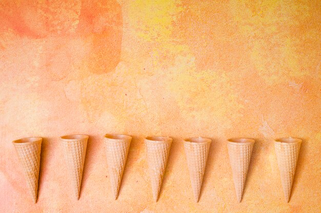 Cones de waffle em linha no plano de fundo multicolorido