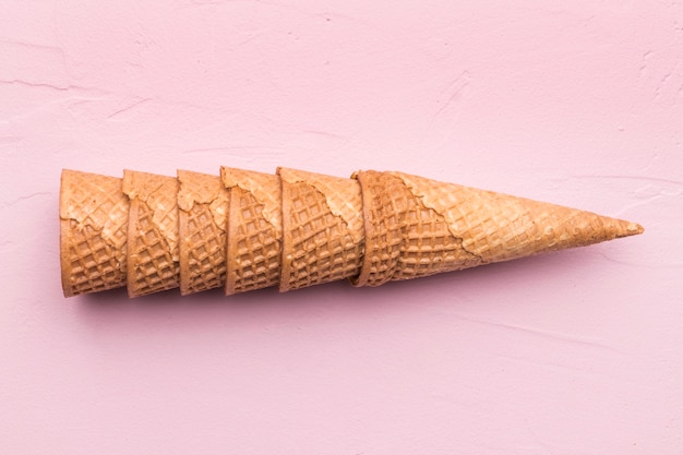 Cones de waffle empilhados no fundo rosa