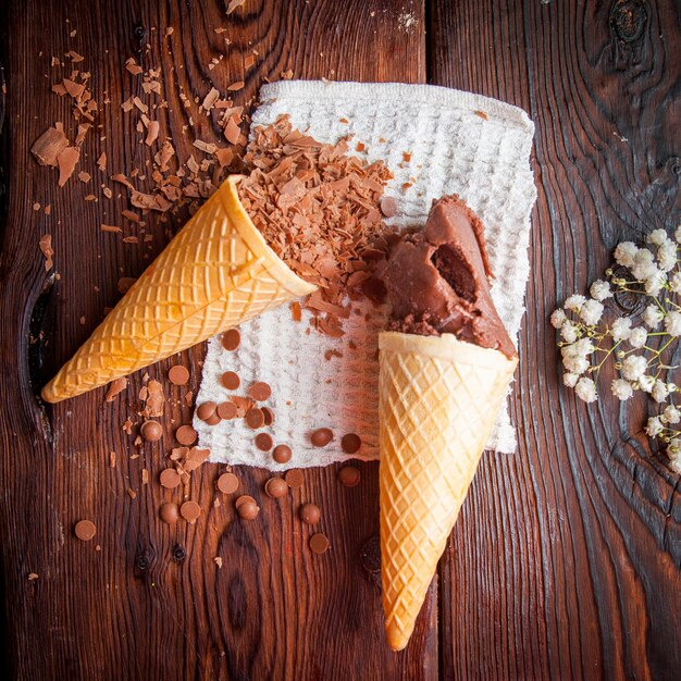 Cones de waffle vista superior com sorvete de chocolate e lascas de chocolate e gypsophila em guardanapos de pano