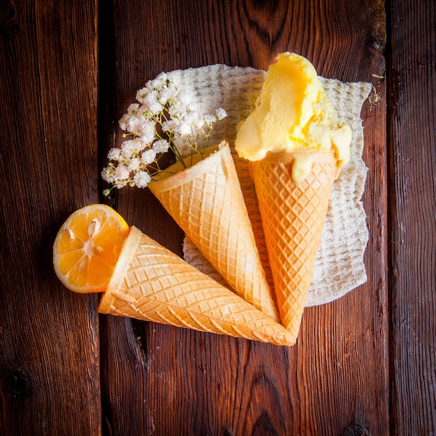 Cones de waffle vista superior com sorvete e laranja e gypsophila em guardanapos de pano