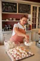 Foto grátis confeiteiro feminino fazendo merengue em uma pastelaria