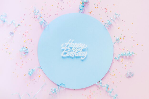 Confetti um flâmulas em torno de escrita de aniversário