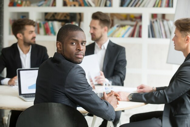 Confiante, americano africano, homem negócios, olhando câmera, sentando, em, reunião