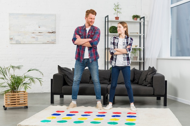 Foto grátis confiante jovem casal em pé na frente do sofá jogando o jogo de cor ponto