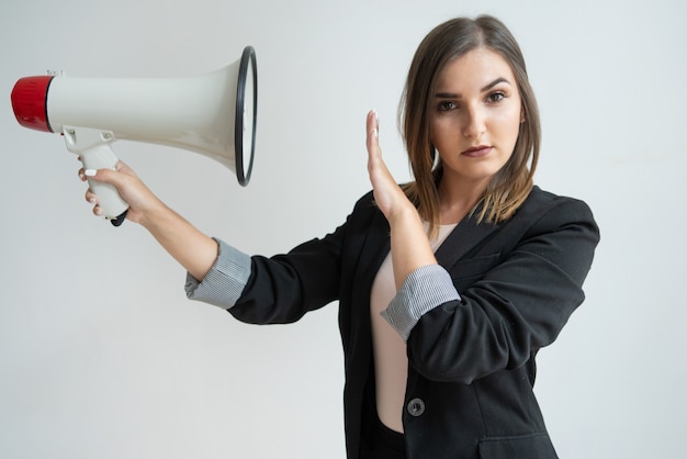 Foto grátis confiante jovem mulher caucasiana dirigindo megafone em si mesma