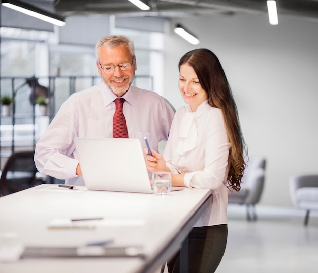 Confiante, sorrindo, homem negócios, e, executiva, olhar, laptop, em, escritório