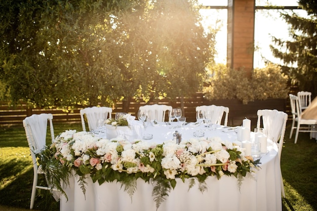 Configuração de mesa elegante na recepção de casamento ao ar livre.