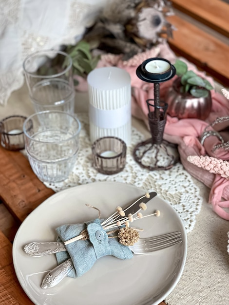 Configuração de mesa festiva com ramos de flores secas e elementos decorativos.