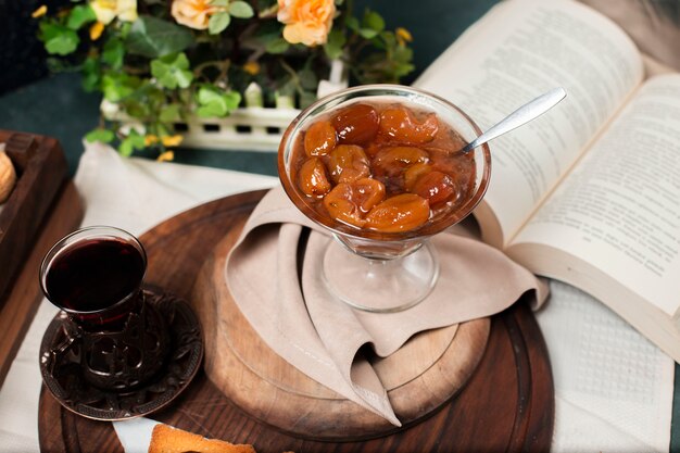 Confiture de figo e um copo de chá preto.