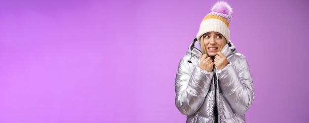 Foto grátis congelando, desconfortável, tremendo, linda garota loira de chapéu, puxando a jaqueta, sentindo frio, andando com neve