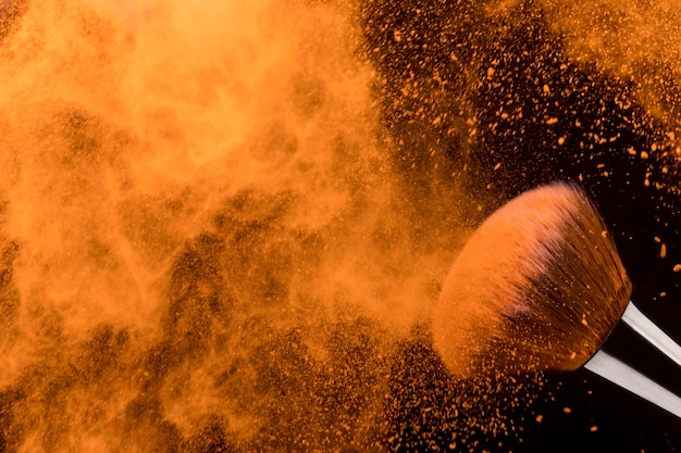 Foto grátis congelar movimento de partículas de pó seco laranja e escova