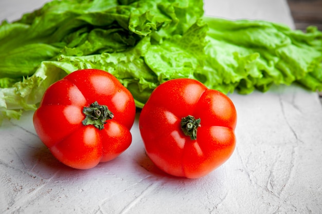 Foto grátis conjunto de alface e tomate em um fundo branco e texturizado. fechar-se.