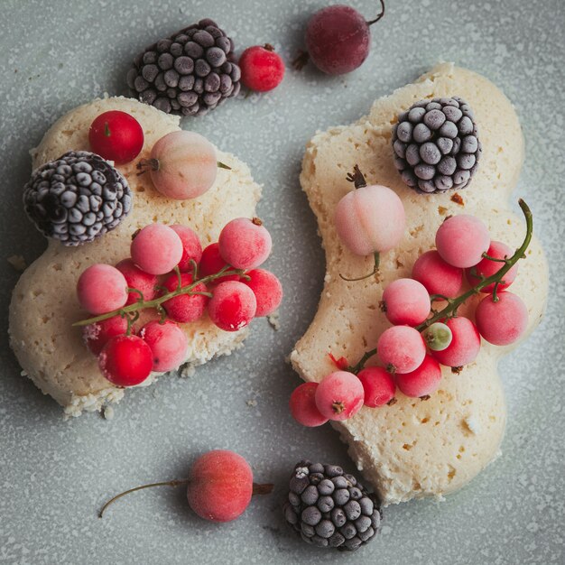 Conjunto de amoras, biscoito e cranberries em um prato em um texturizado.