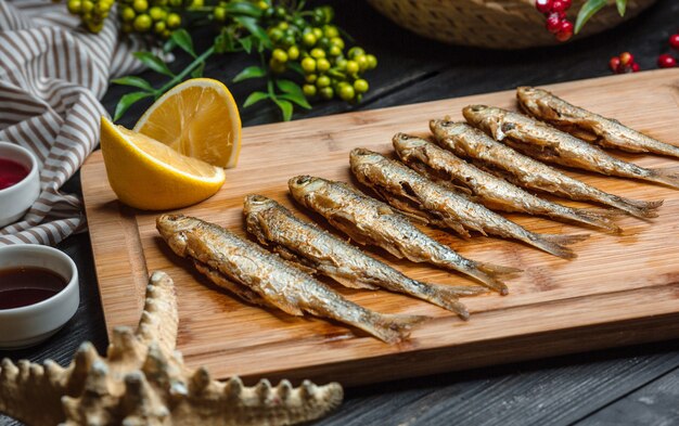 Conjunto de peixes fritos na placa de madeira