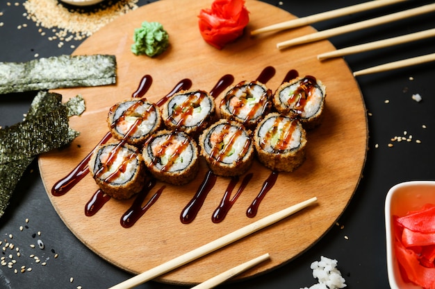 Foto grátis conjunto de rolo de sushi na mesa coberto com vista superior do molho