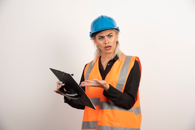 Construtor de mulher descontente, apontando na área de transferência. foto de alta qualidade