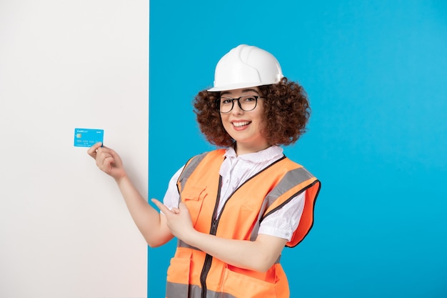 Construtora de frente, de uniforme, com cartão de crédito azul sobre azul