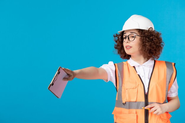 Construtora de frente em uniforme controlando o trabalho no azul