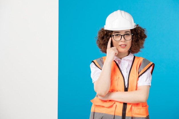 Foto grátis construtora de frente pensando em uniforme na parede azul