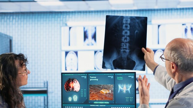 Consulta de oncologia ocorre enquanto um médico sênior explica a varredura radiológica