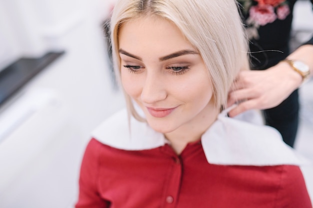 Content girl sitting on chair of hairstylist