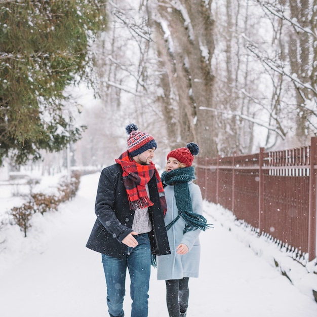 Conteúdo jovem casal correndo na rua nevado
