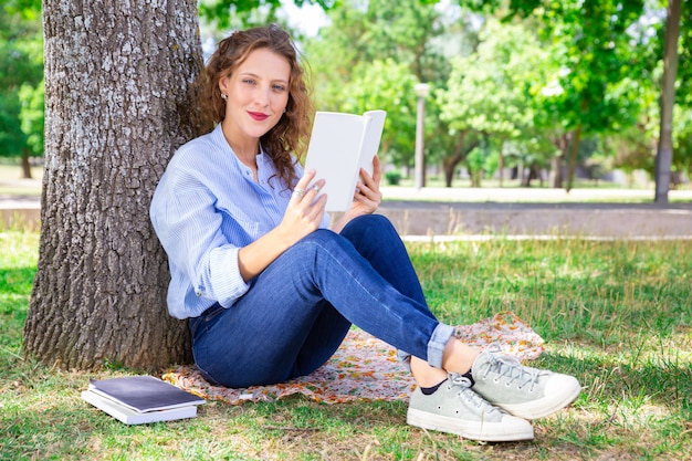 Conteúdo menina bonita lendo livro no parque