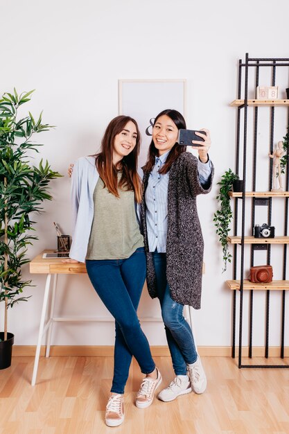 Conteúdo meninas elegantes usando o telefone para o selfie