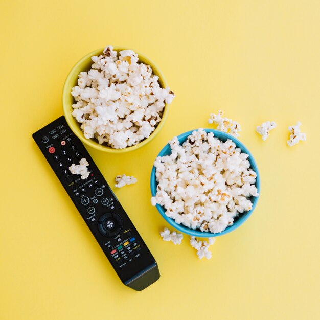 Controle remoto de TV perto de tigelas com pipoca