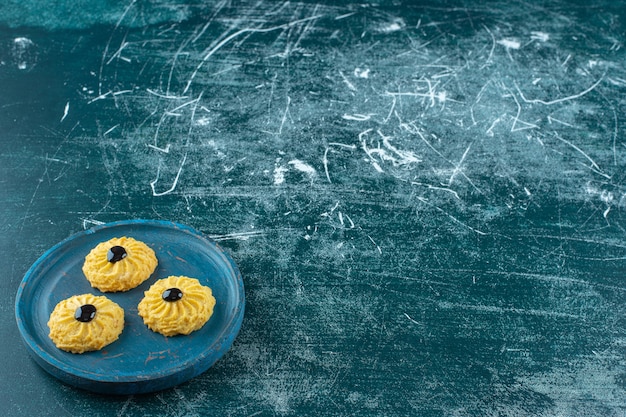 Cookie com chocolate em uma placa de madeira, sobre o fundo azul. foto de alta qualidade