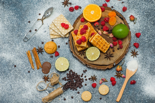 Cookies com farinha, ervas, frutas, especiarias, choco, vista superior do coador na placa de madeira e fundo de estuque