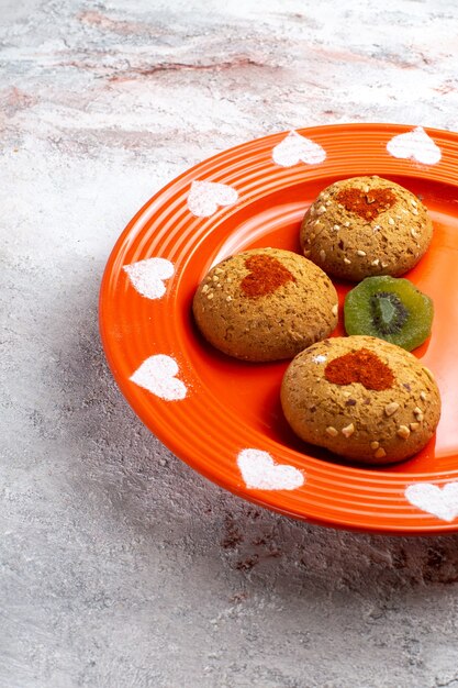 Foto grátis cookies de açúcar redondos de vista frontal dentro do prato na superfície branca biscoitos biscoito açúcar bolo doce