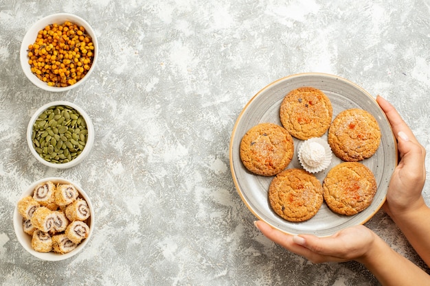 Foto grátis cookies de areia doce de vista superior com sementes em fundo branco