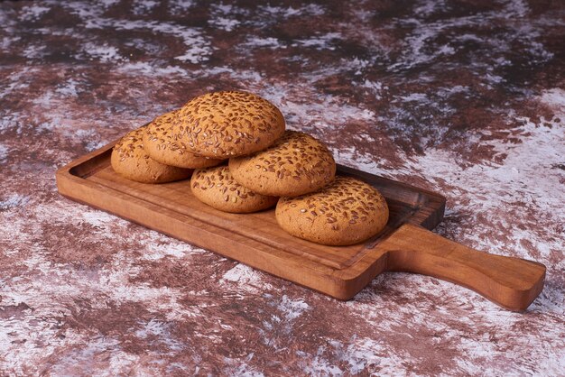 Cookies de aveia com cominho preto em uma travessa de madeira sobre o mármore.