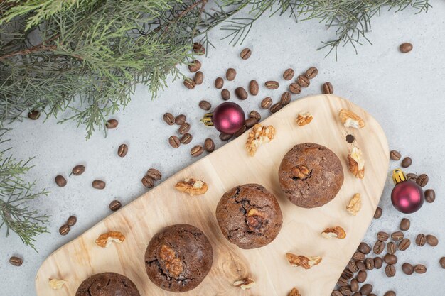 Cookies de chocolate com nozes e grãos de café na placa de madeira