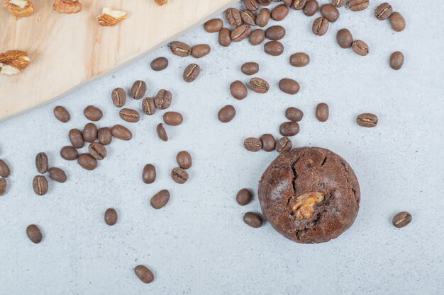 Cookies de chocolate com nozes e grãos de café na placa de madeira