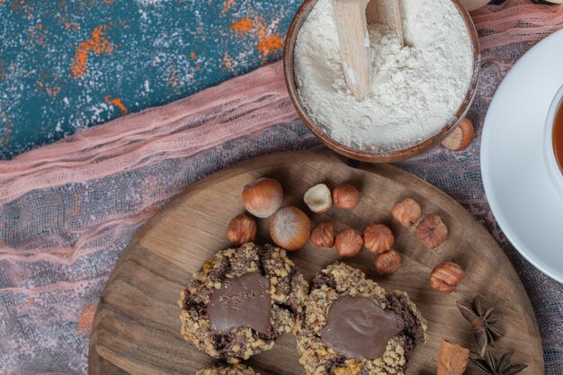 Cookies de chocolate crocante com nozes em uma placa de madeira.