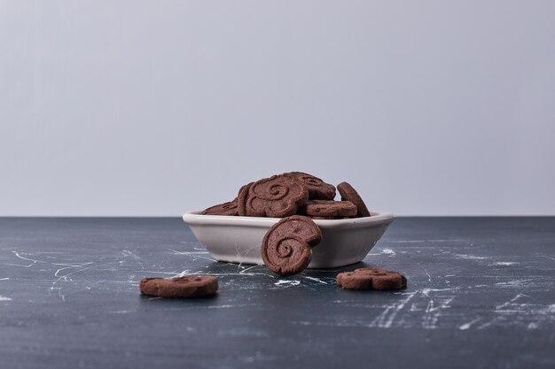 Cookies de chocolate em um prato de cerâmica branca.