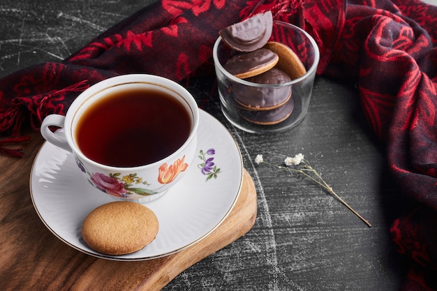 Cookies de chocolate em uma xícara de vidro com chá.