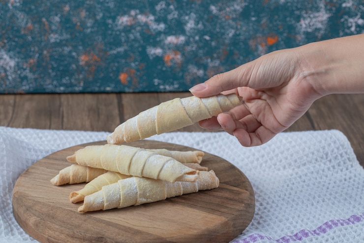 Foto grátis cookies de mutaki caucasianos longos e estreitos com açúcar em pó na parte superior.