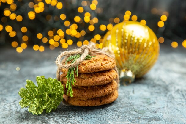 Cookies de vista frontal amarrados com cordas de enfeites de natal em fundo cinza