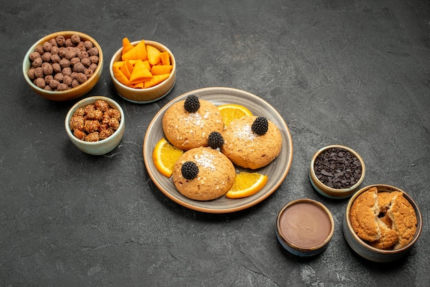 Cookies deliciosos de cima com batatas fritas e nozes em uma superfície cinza-escura biscoito biscoito chá doce bolo