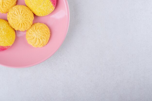 Cookies em um prato rosa na mesa de mármore.