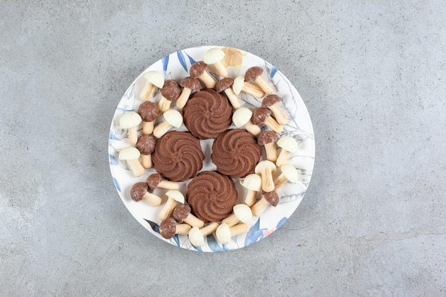 Cookies rodeados por cogumelos de chocolate em um prato com fundo de mármore. Foto de alta qualidade